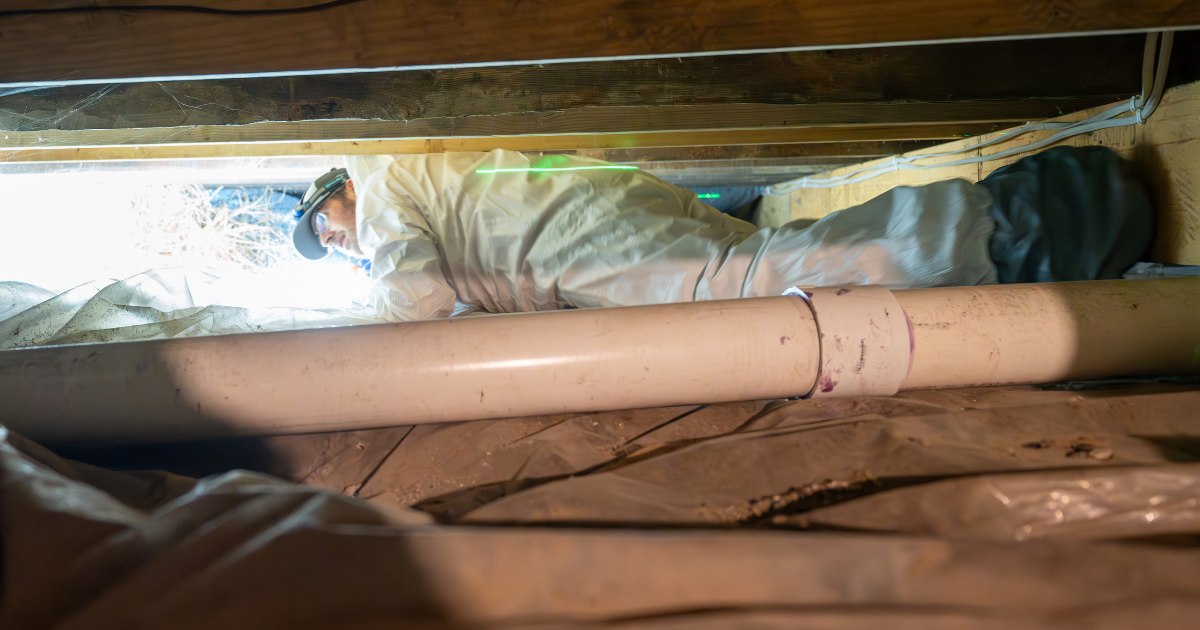 Hitman Solutions team member during crawlspace inspection for water intrusion